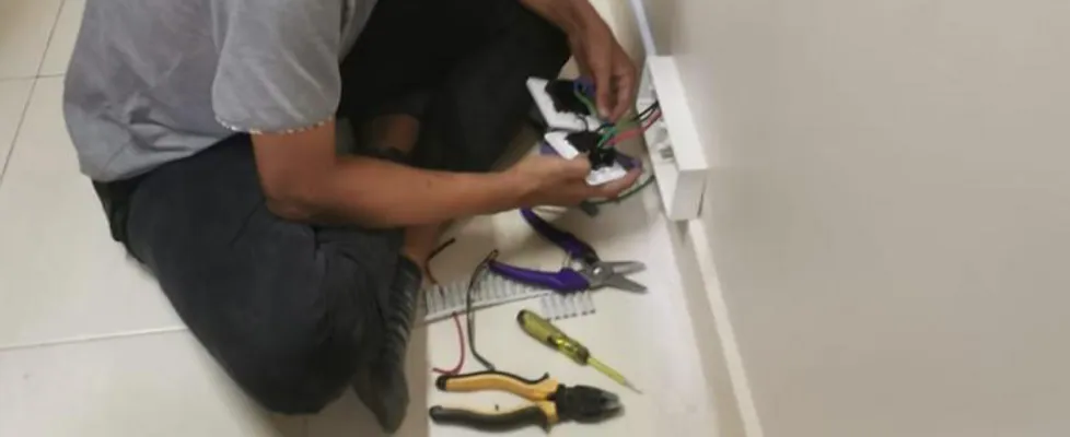 Electrician fitting wiring at a wall socket